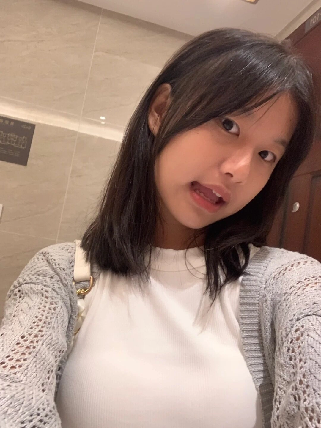 Mái tóc ngang vai nhẹ nhàng, nụ cười tinh nghịch đầy cuốn hút giữa ánh đèn vàng.