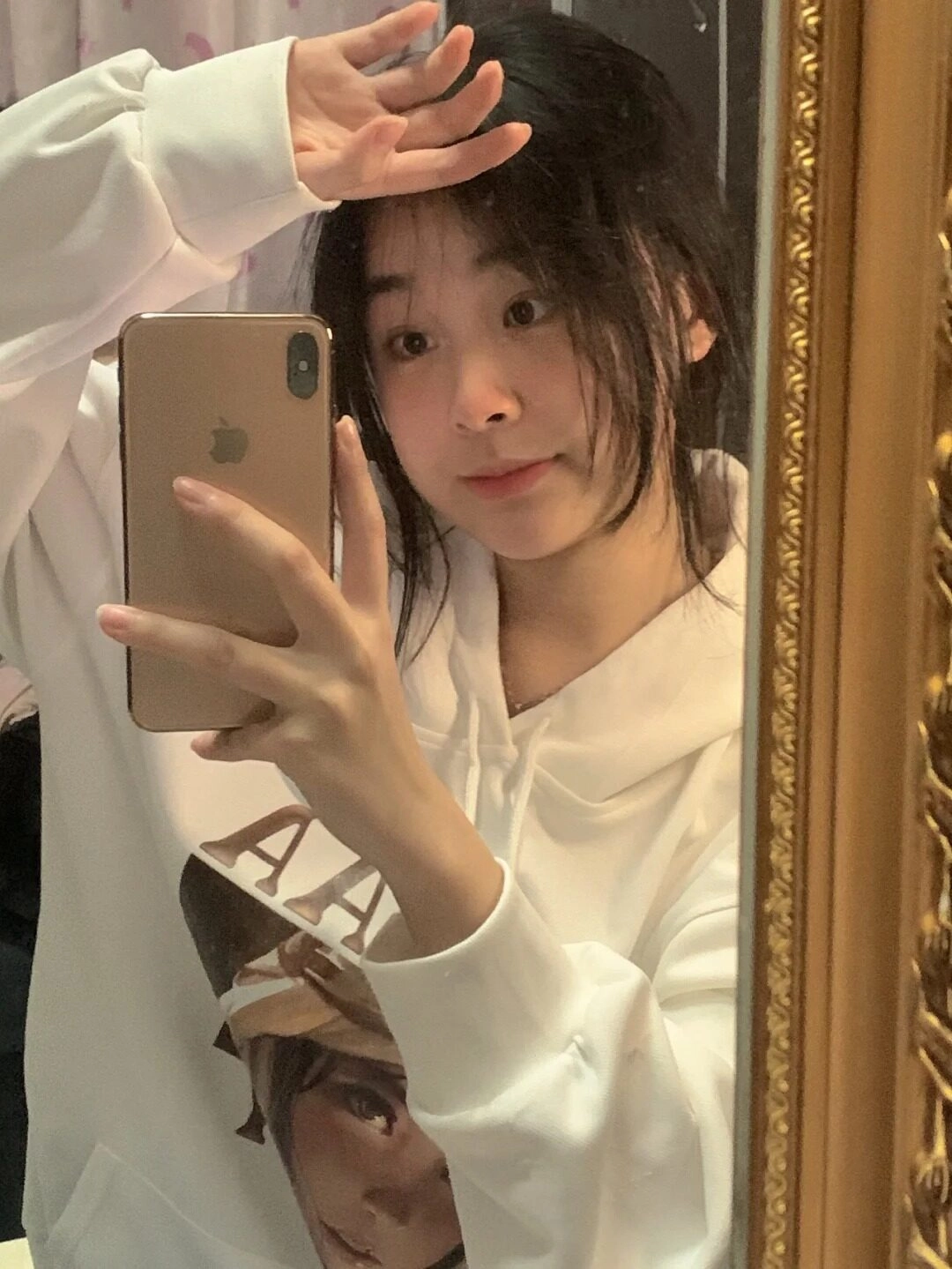 Tinh nghịch đưa tay lên trán selfie trước gương.