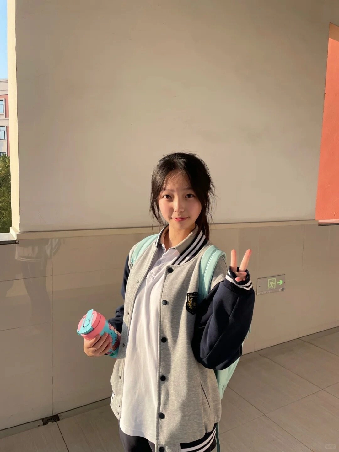 Cô gái vẫy tay chào, nụ cười tươi rạng rỡ bắt đầu ngày học mới.