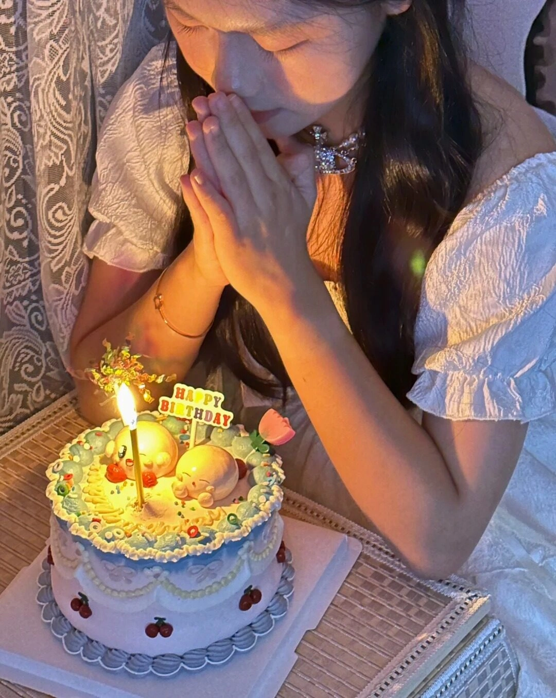 Em gái đang chắp tay đọc điều ước của mình nhân dịp sinh nhật