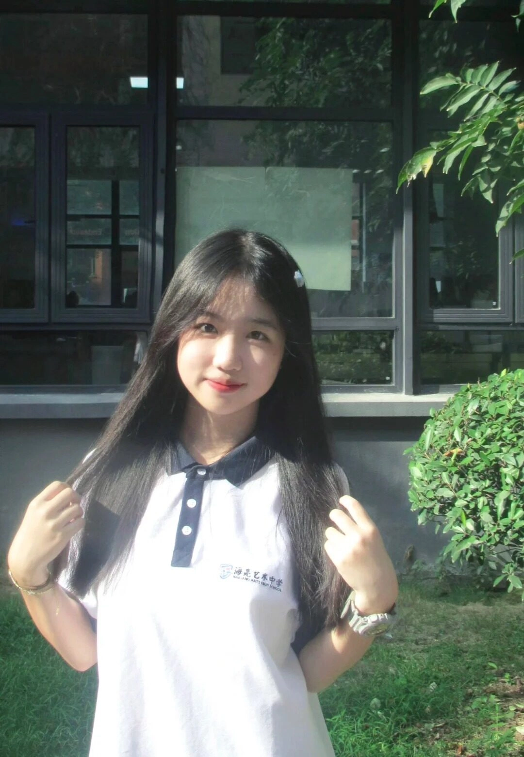 Khoảnh khắc cô nữ sinh nhẹ nhàng vuốt mái tóc dài dưới ánh nắng.