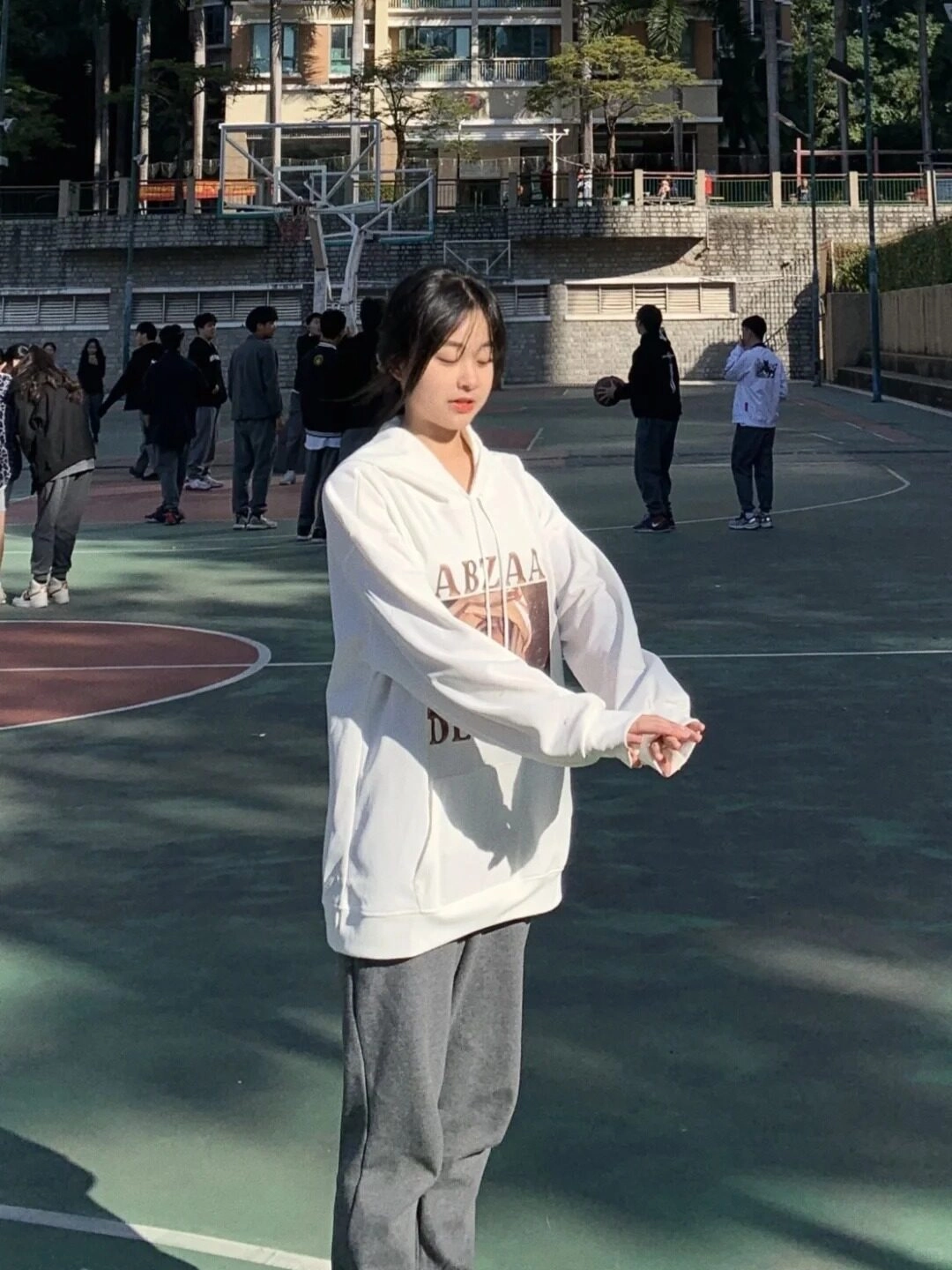 Cô gái khởi động tay thư giãn, tận hưởng giờ thể thao dưới nắng đẹp.