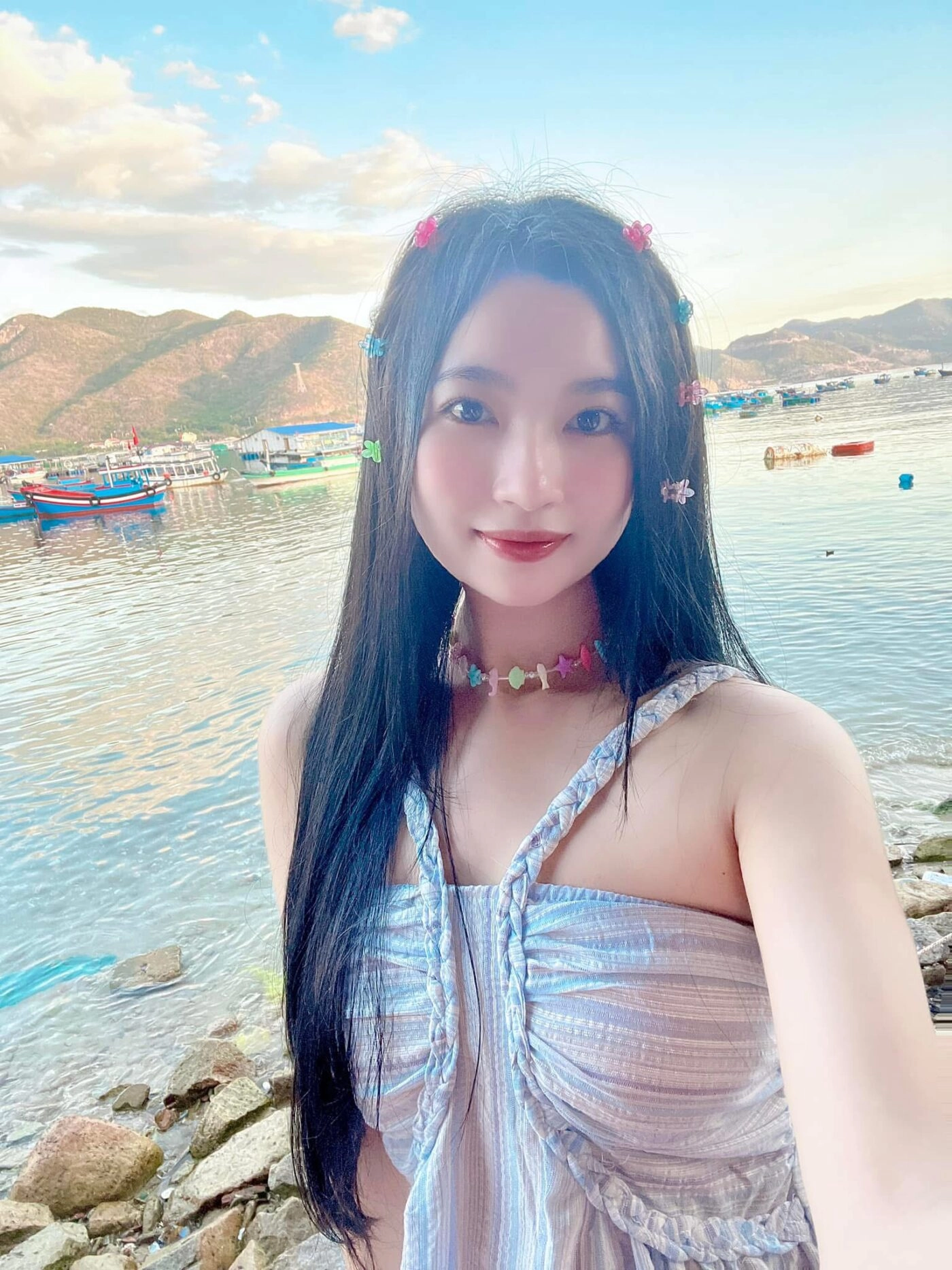 Gái xinh váy xanh nhạt cùng phụ kiện tóc dễ thương, nụ cười trong sáng rạng ngời.