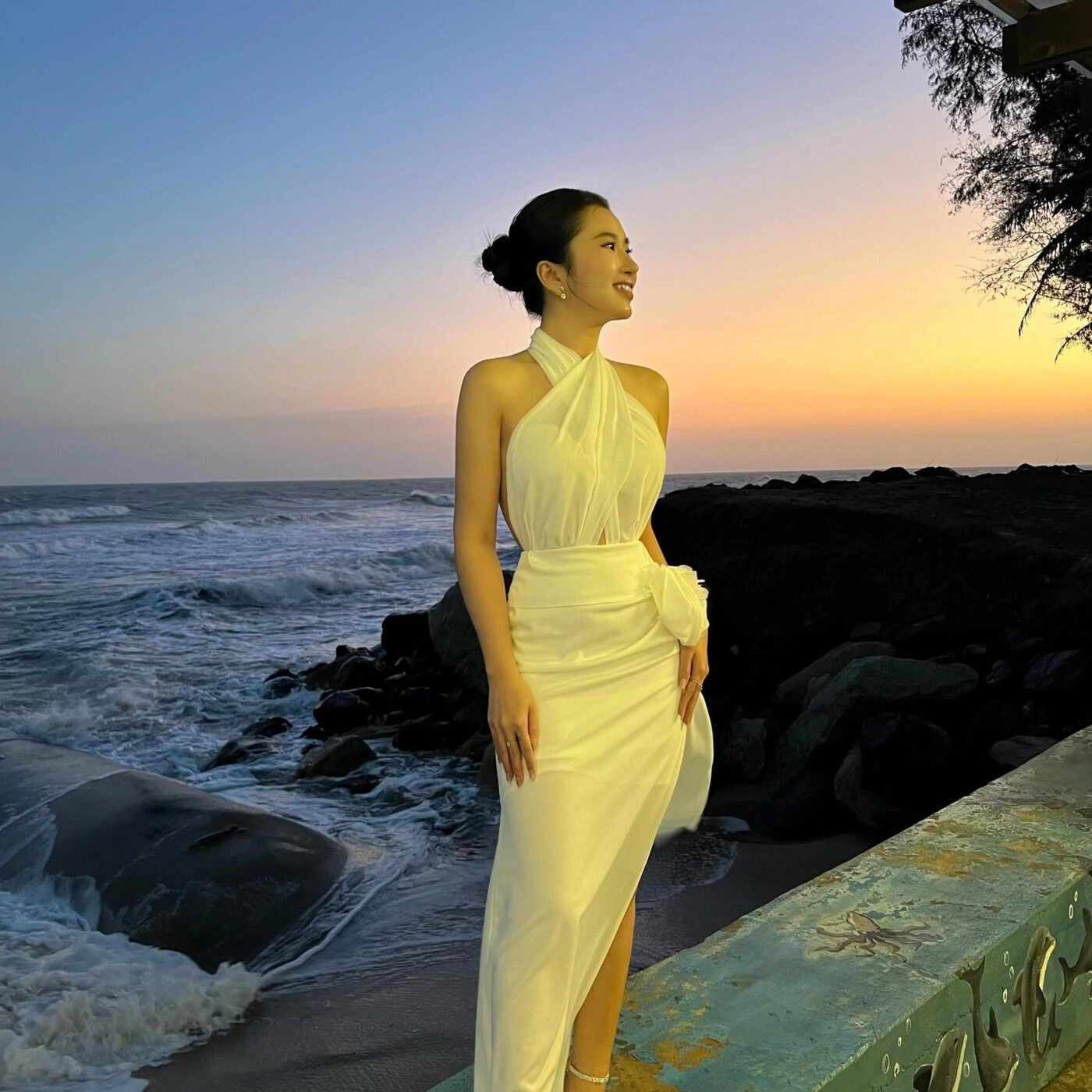 Đầm ôm trắng giữa hoàng hôn, nụ cười rạng rỡ tôn lên vẻ đẹp khó sa.