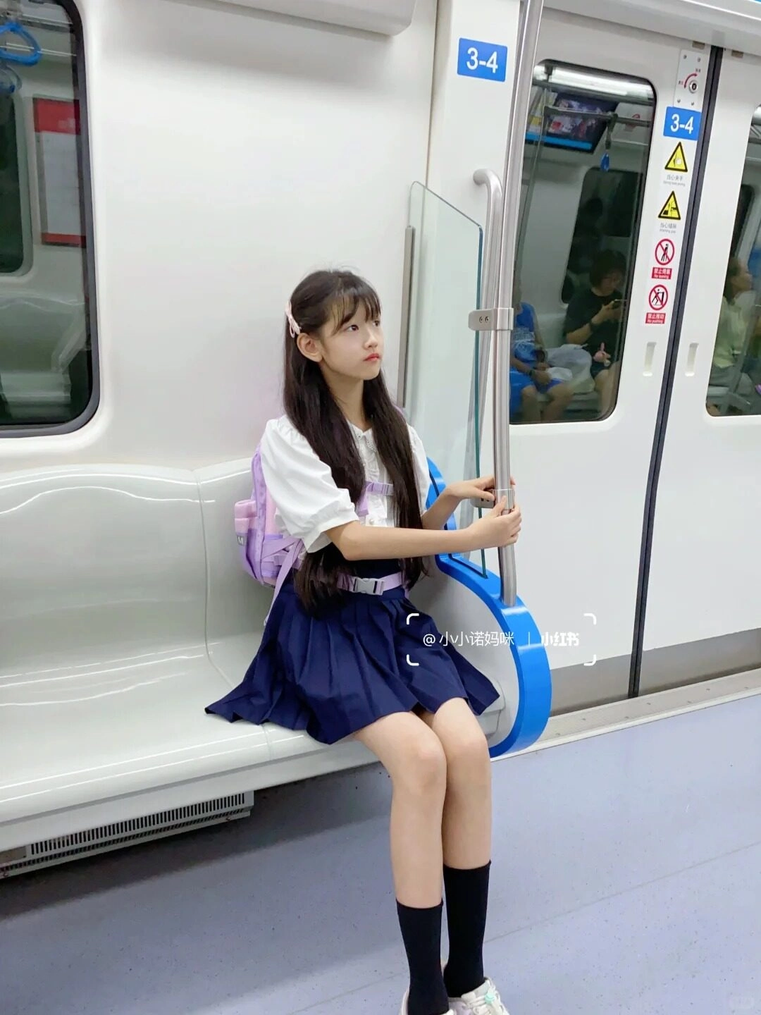 Cô bé ngồi trên tàu điện, ánh mắt ngơ ngác nhìn xa xăm.