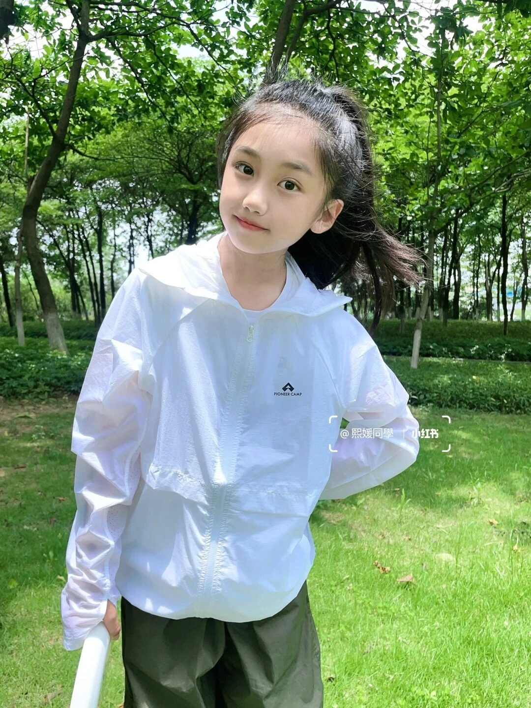 Nụ cười tươi sáng trong ánh nắng nhẹ, giữa không gian xanh mát.