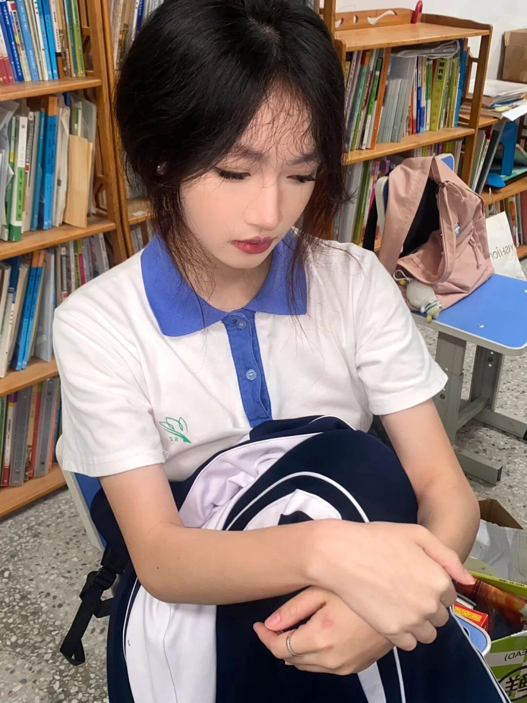 Ngồi trong lớp học, ánh mắt cụp xuống, tâm trạng lặng thinh.
