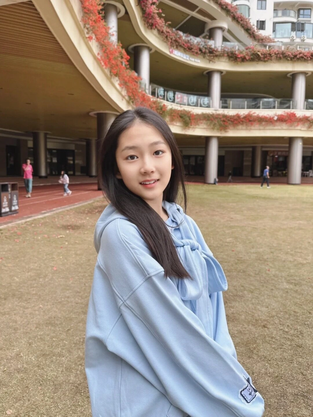 Cô gái nhỏ với áo hoodie xanh pastel, gương mặt xinh xắn đáng yêu.