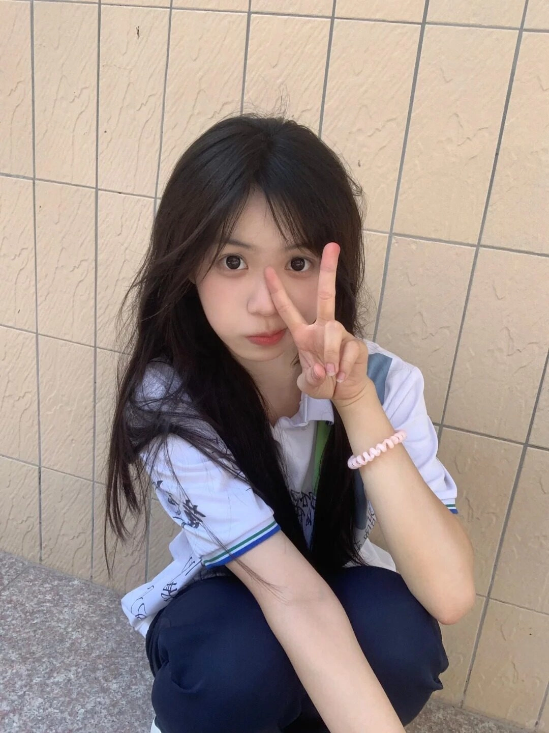 Nữ sinh tạo kiểu "hòa bình" tinh nghịch, tóc xoăn dài xõa tự nhiên.