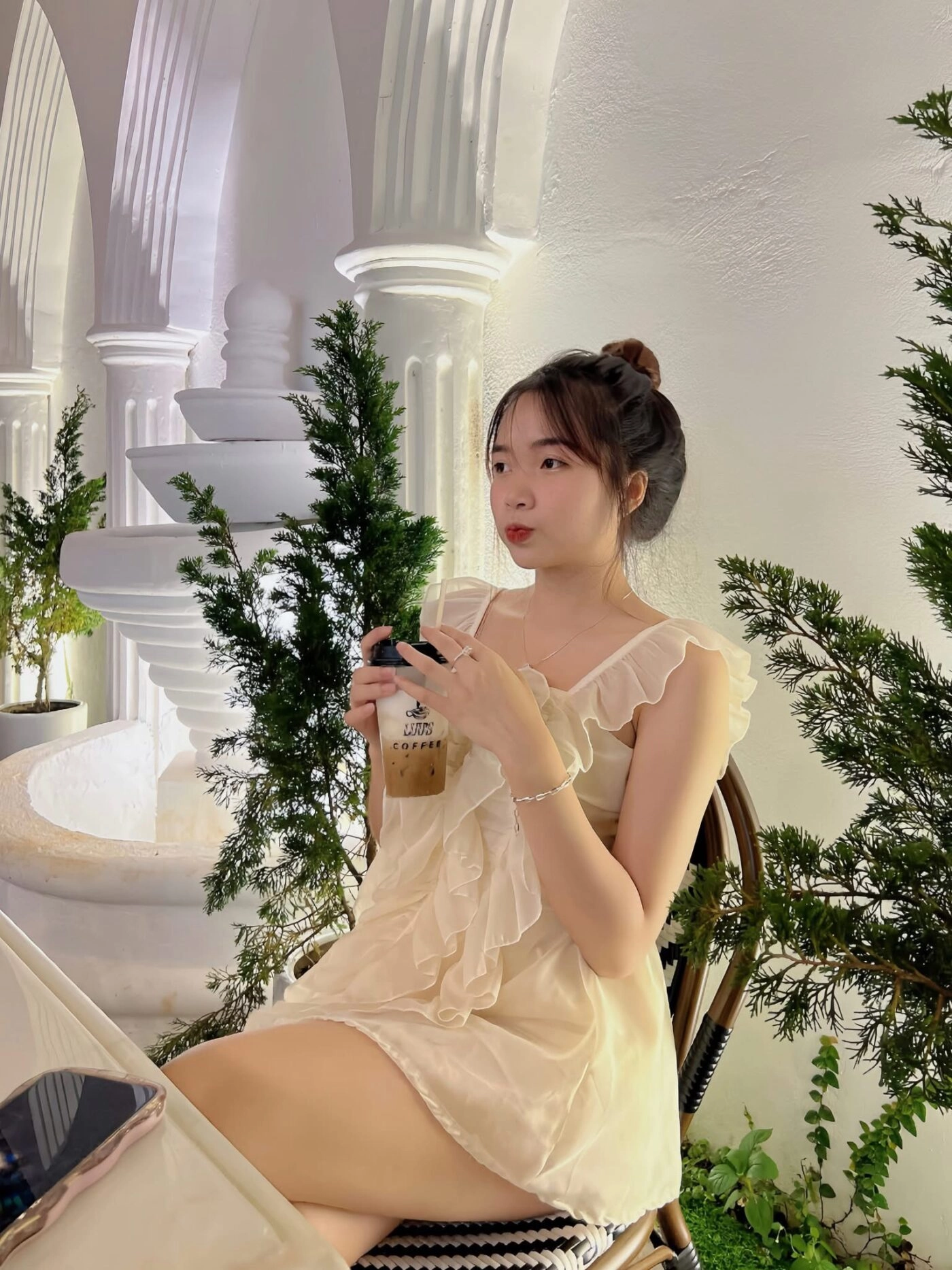 Ngồi yên bên ly cà phê, ánh đèn dịu nhẹ làm khung hình lung linh