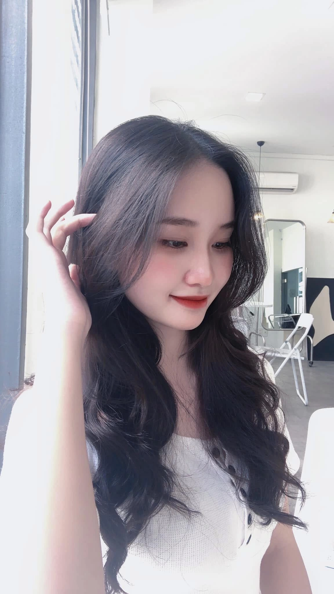 Nét dịu dàng qua ánh mắt và nụ cười nhẹ giữa ánh sáng ngập tràn quán