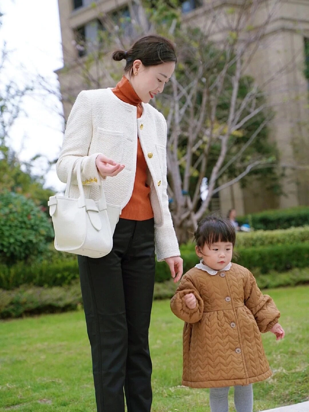 Áo khoác dày ấm áp, nắm tay con gái nhỏ trong tiết trời se lạnh.