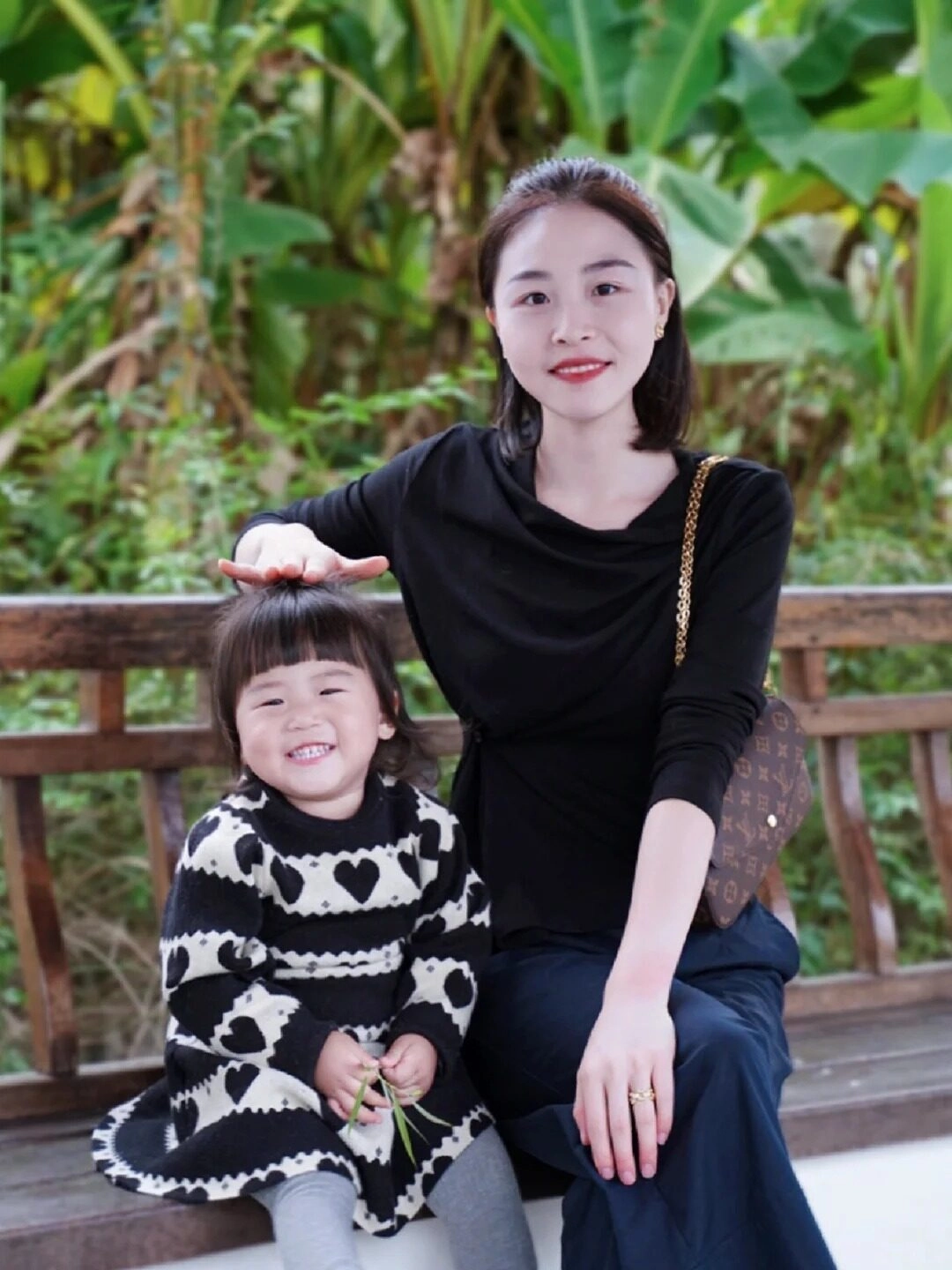 Mẹ xoa đầu con gái, cả hai cười rạng rỡ trong trang phục đen trắng cá tính.