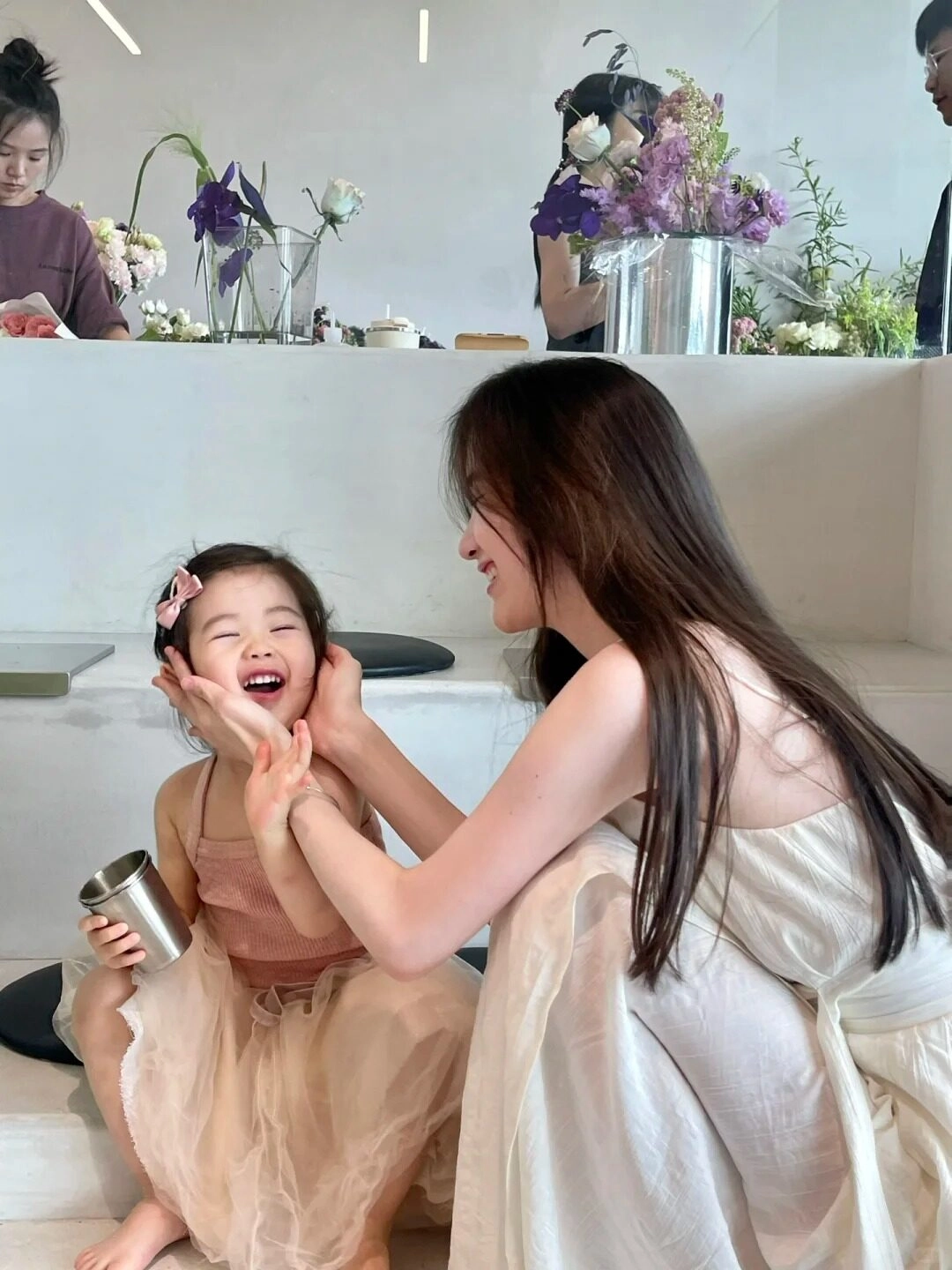 Mẹ và con cùng diện váy voan nhẹ nhàng, mẹ nâng má con yêu đầy yêu thương.