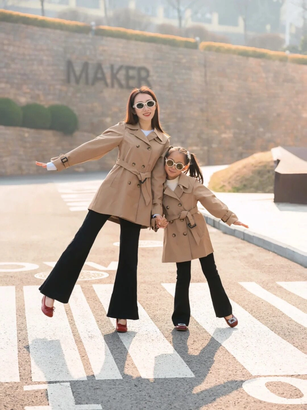 Mẹ và con diện trench coat đôi, tạo dáng tự tin trên phố đầy nắng.