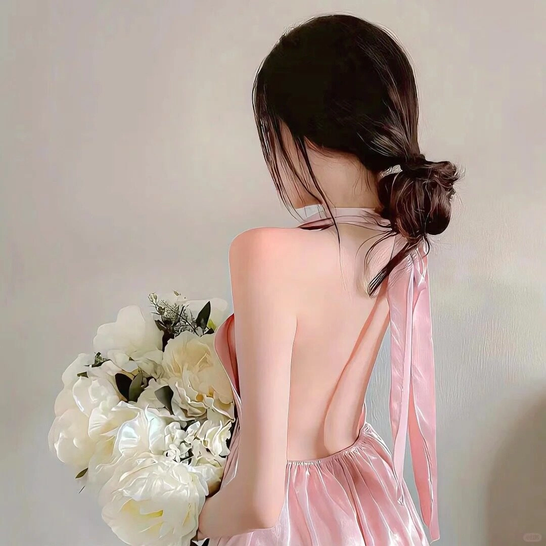 Cô gái váy lụa hồng, lưng trần thanh thoát ôm hoa trắng lớn.