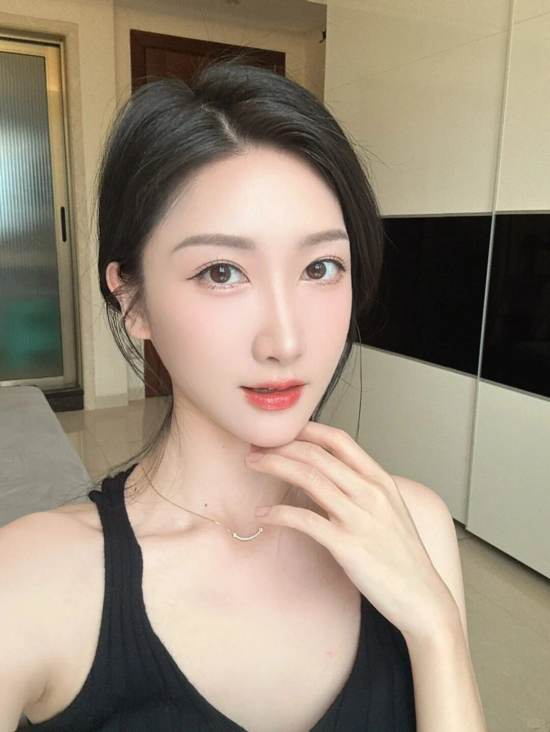Kiểu tóc búi thấp, diện áo ba lỗi đen, vẻ đẹp tinh tế và sang trọng.