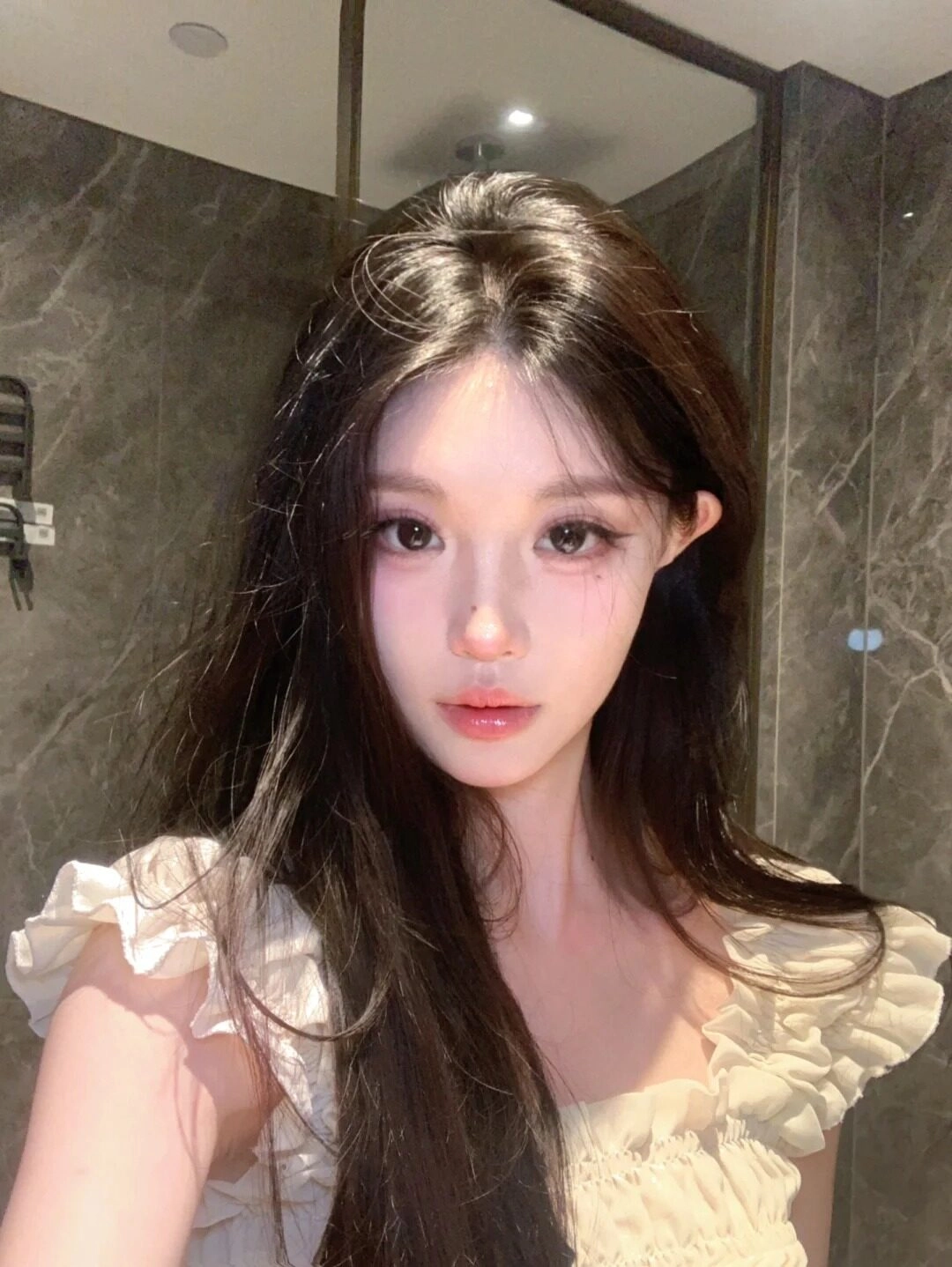 Selfie cận mặt, tóc dài bồng bềnh, áo trắng bèo đắp nữ tính, ánh nhìn quyến rũ.