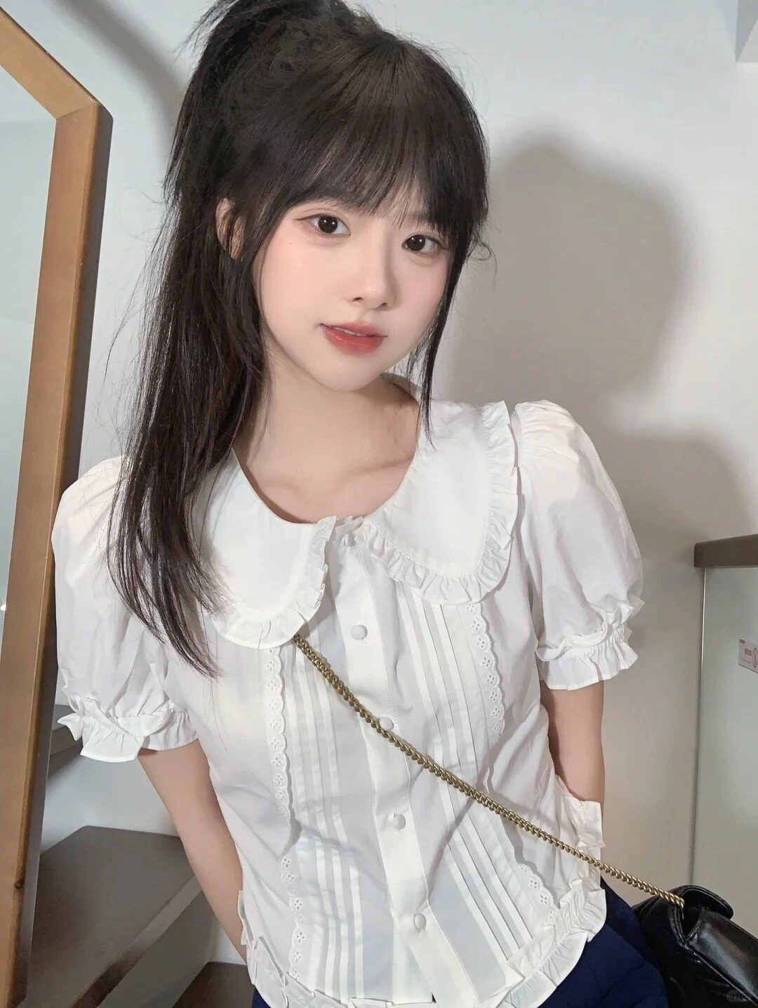 Nụ cười tươi viền, tóc cột cao, áo sơ mi cổ bèo siêu dễ thương