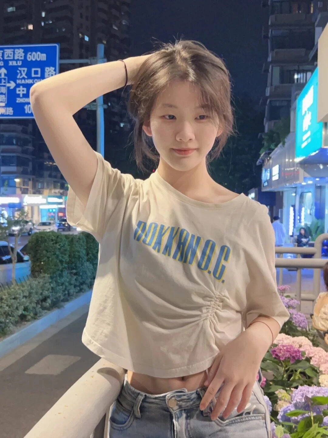 Nàng hot girl 2k9 tạo kiểu dáng cá giữa đêm, tóc búi nhẹ, trang phục trẻ trung năng động.