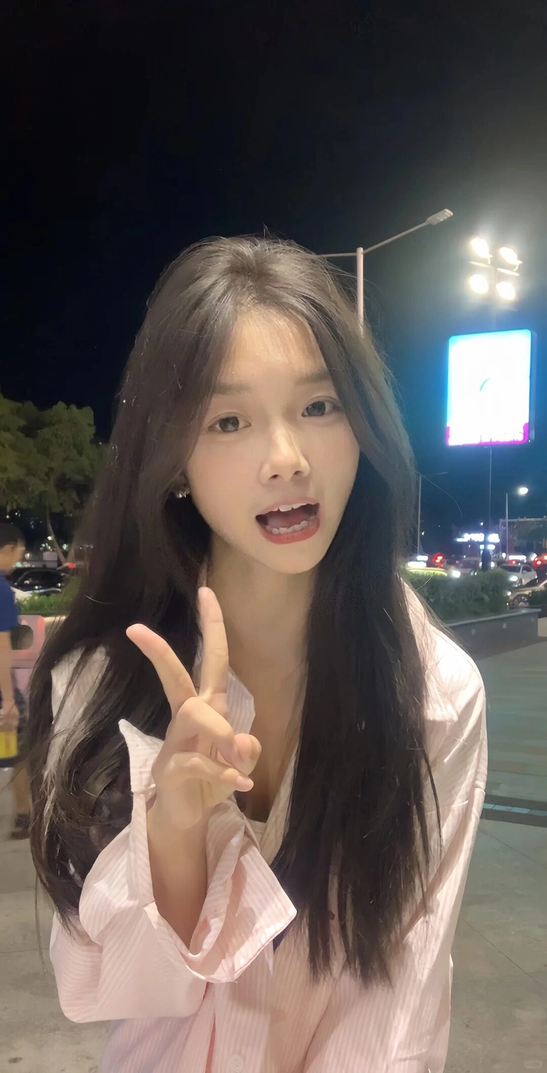 Bạn nữ tạo kiểu dáng chữ V tinh nghịch, tóc dài buông xõa tự nhiên.