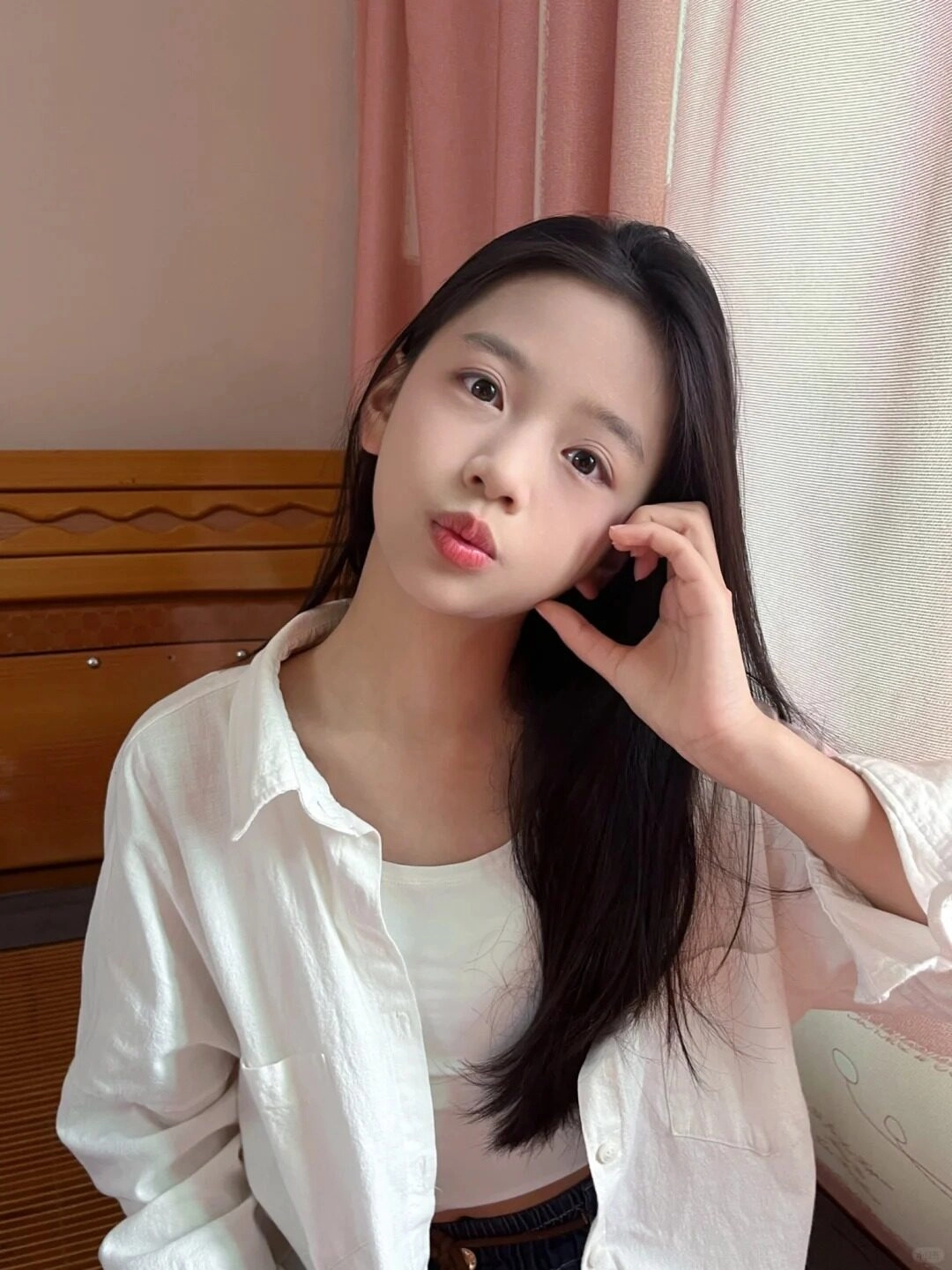 Thiếu áo sơ mi nữ mi trắng đơn giản, tóc dài thẳng, tạo kiểu dáng vừa vặn bên cửa sổ.