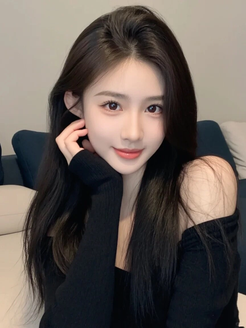 Cô gái áo len đen tuyền vai, tóc dài mượt, thoáng nụ cười quyến rũ quyến rũ.