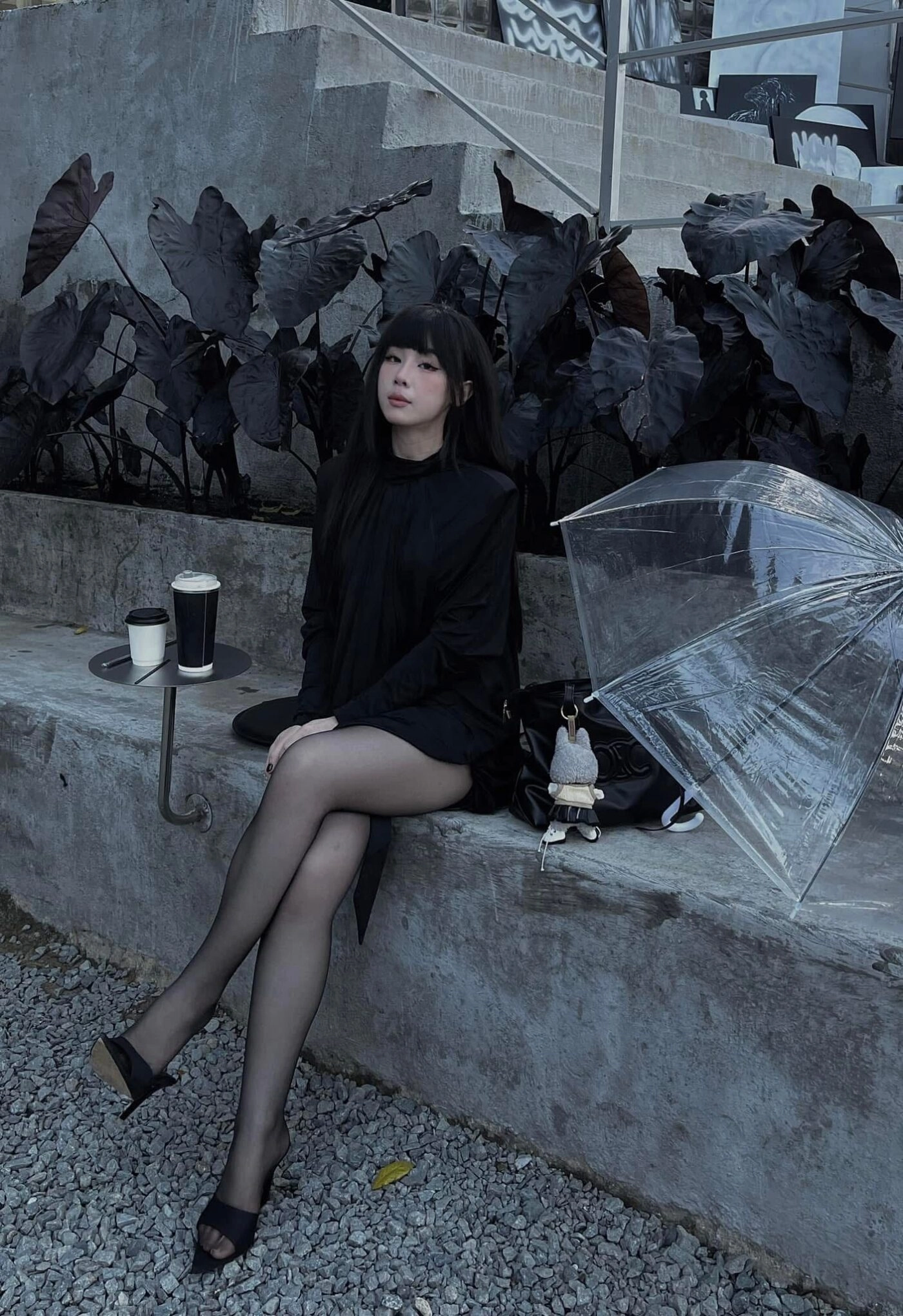 Outfit all black thần thái, tóc suôn dài và dù trong suốt tạo vibe hơi lạnh lùng