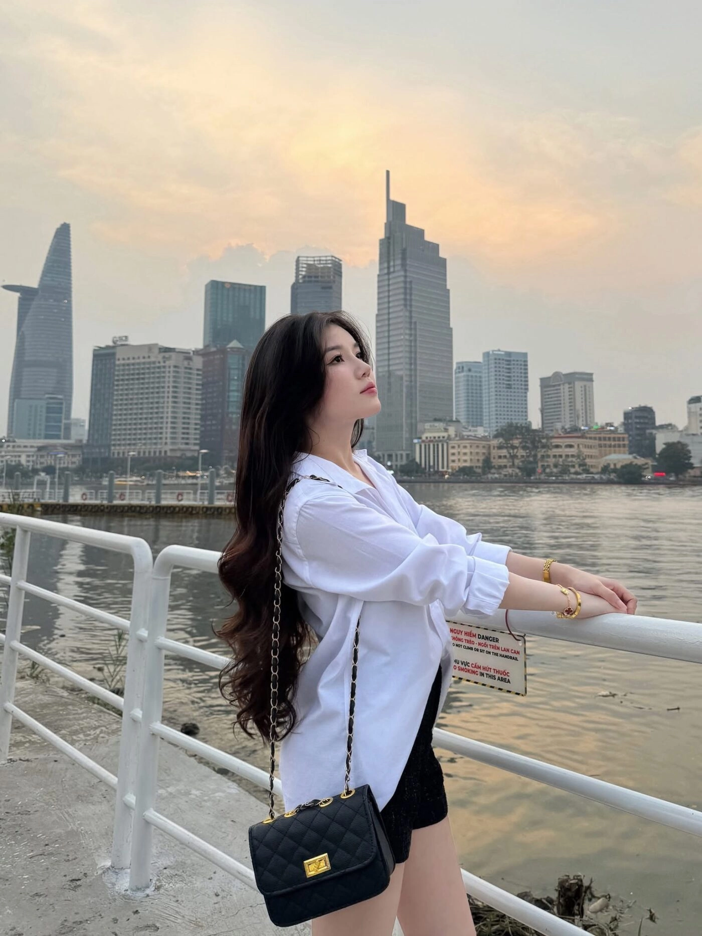 Tóc xoăn dài bồng bềnh phối áo sơ mi trắng tạo vẻ đẹp dịu dàng giữa phố thị