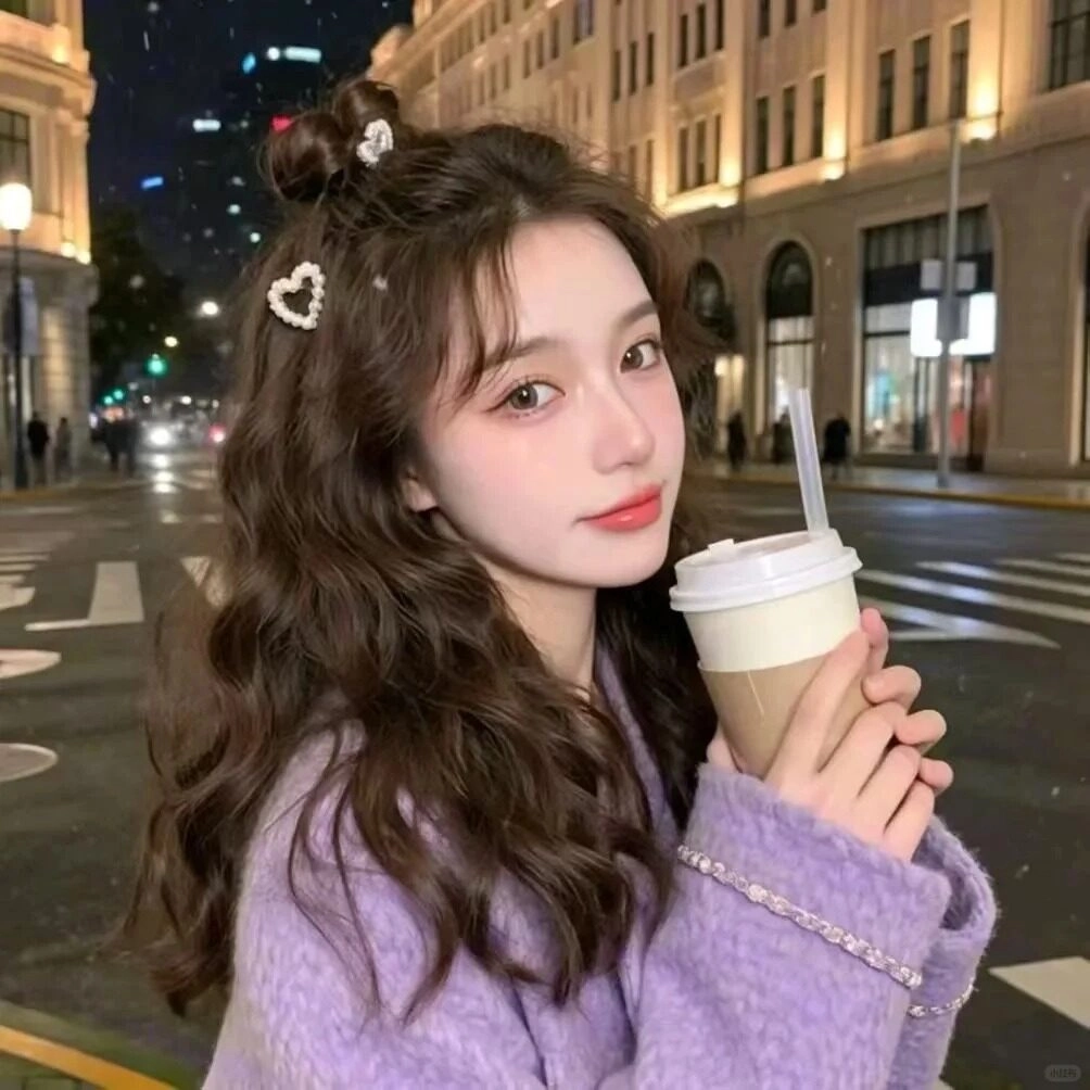 Áo tím, kiểu tóc xoăn bồng bềnh cùng phụ kiện trái tim dễ thương.