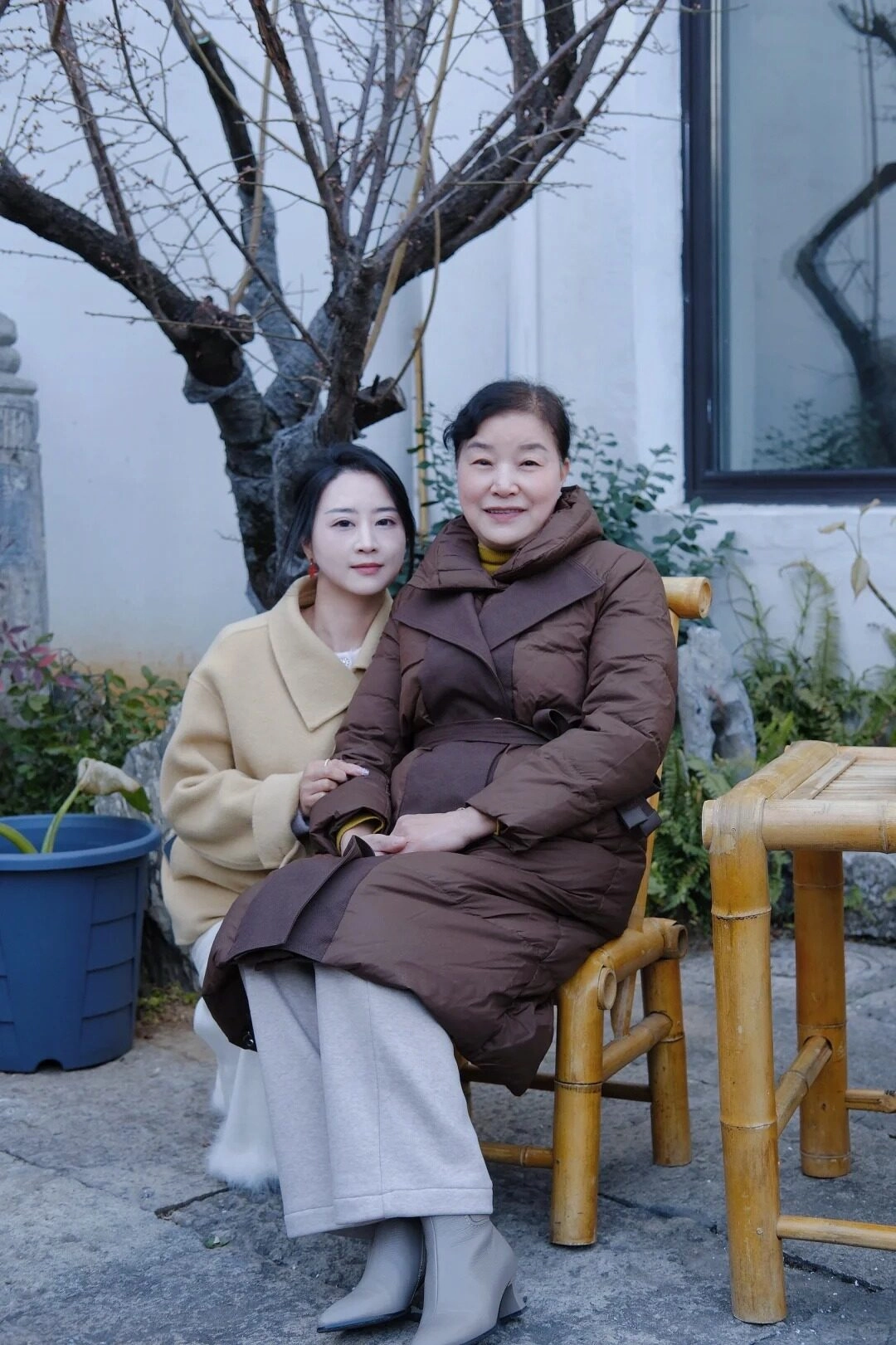 Mẹ và con gái diện áo khoác dày ấm áp, cùng nhau tạo dáng bên khung cảnh mùa đông.