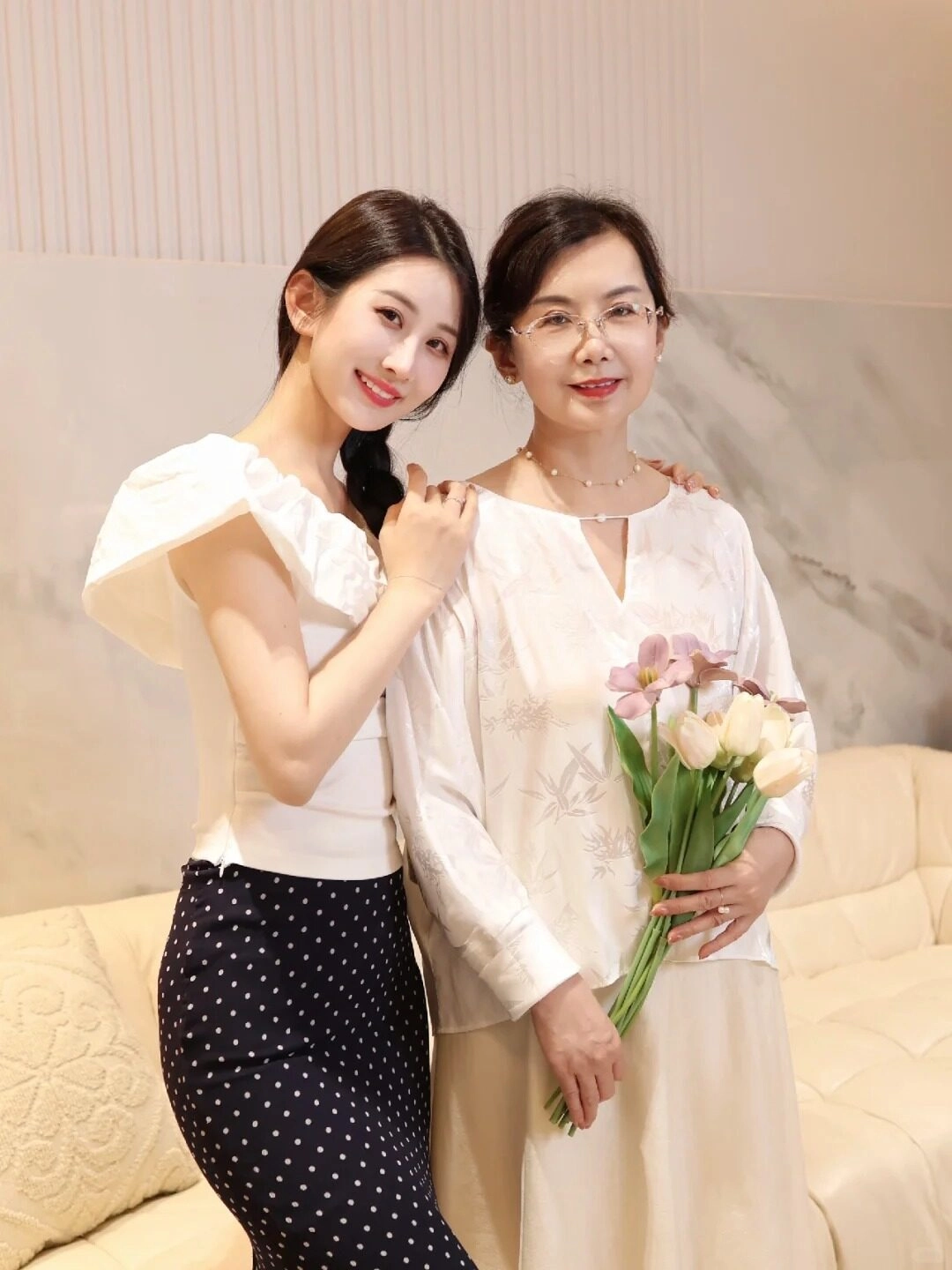 Bó hoa tươi trong tay mẹ, con gái dịu dàng tựa vào vai mẹ hạnh phúc.
