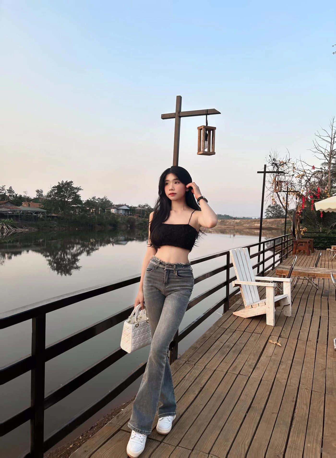 Áo croptop đen kết hợp quần jeans, kiểu dáng tự tin bên hồ nước trong