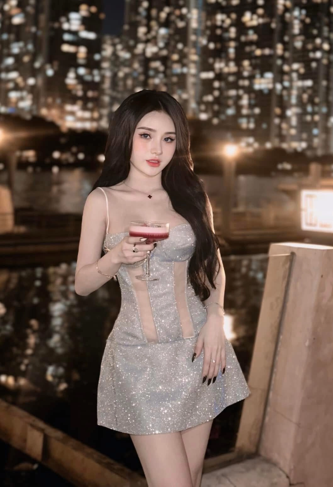 Váy kim tuyến lấp lánh, cầm ly cocktail, thần thái sang trọng về đêm.