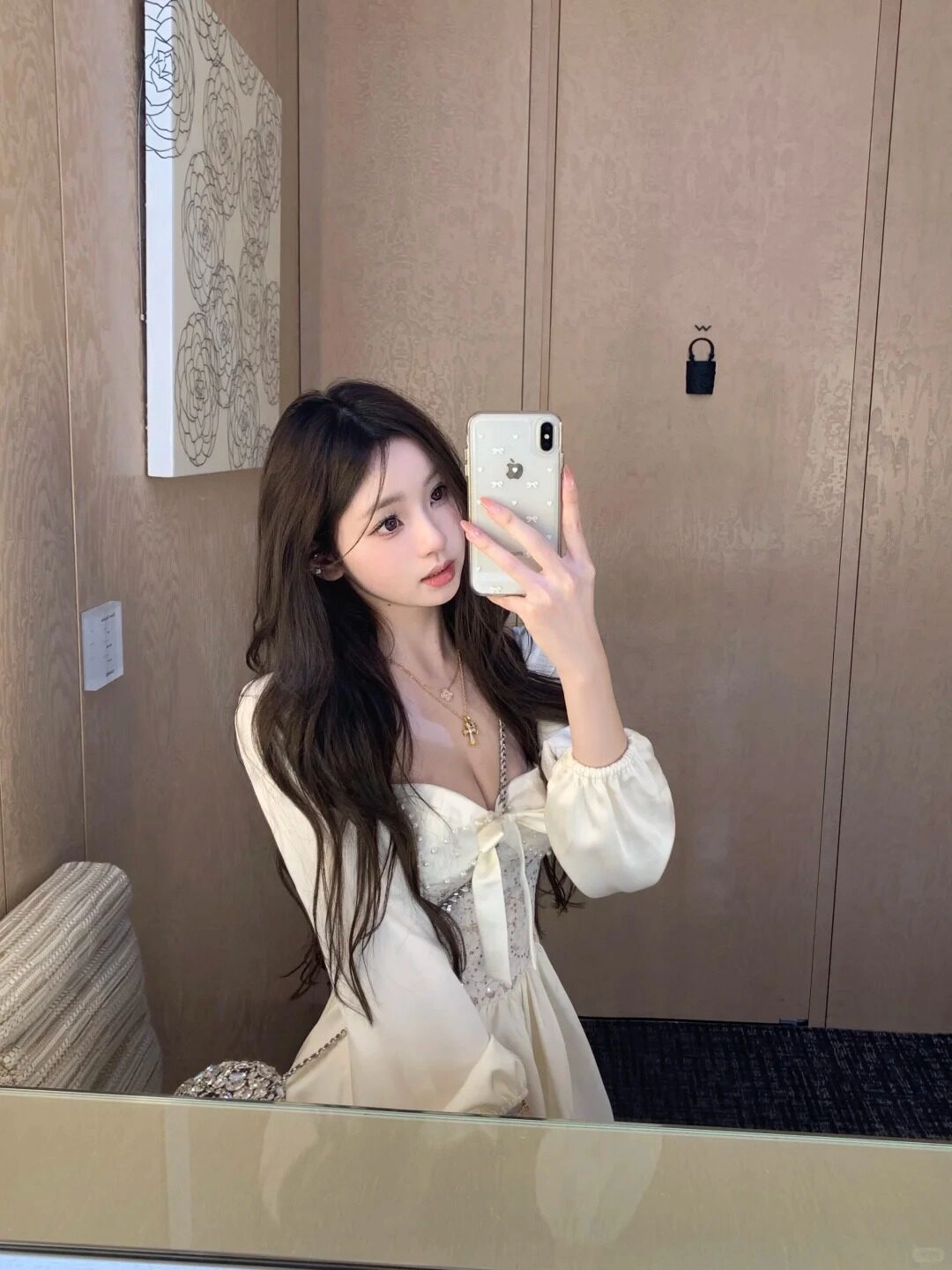 Váy công trắng váy nữ tính, tóc dài xoăn nhẹ nhàng, biểu cảm ngọt ngào trước gương.