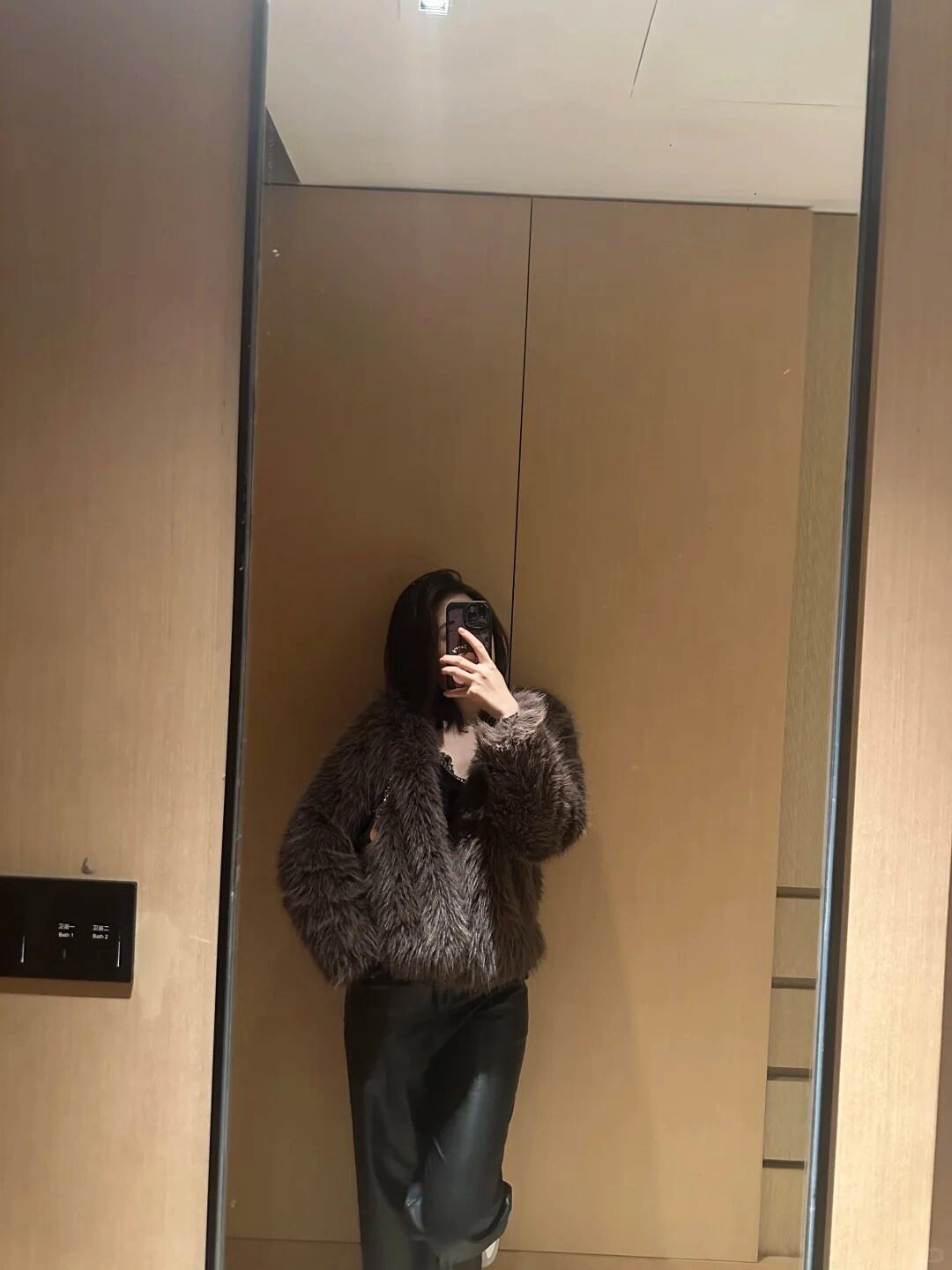 Cô gái mặc áo khoác lông cá tính, phối đồ sành điệu trước gương.