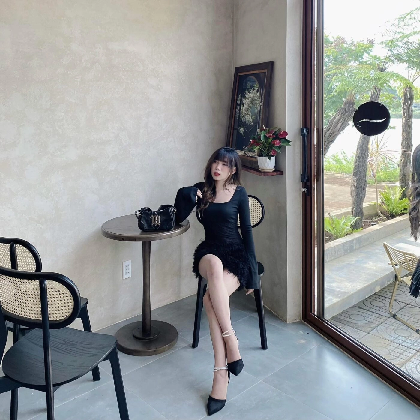 Đầm đen ôm body, tóc dài uốn đuôi nhẹ, thần thái cực sang.