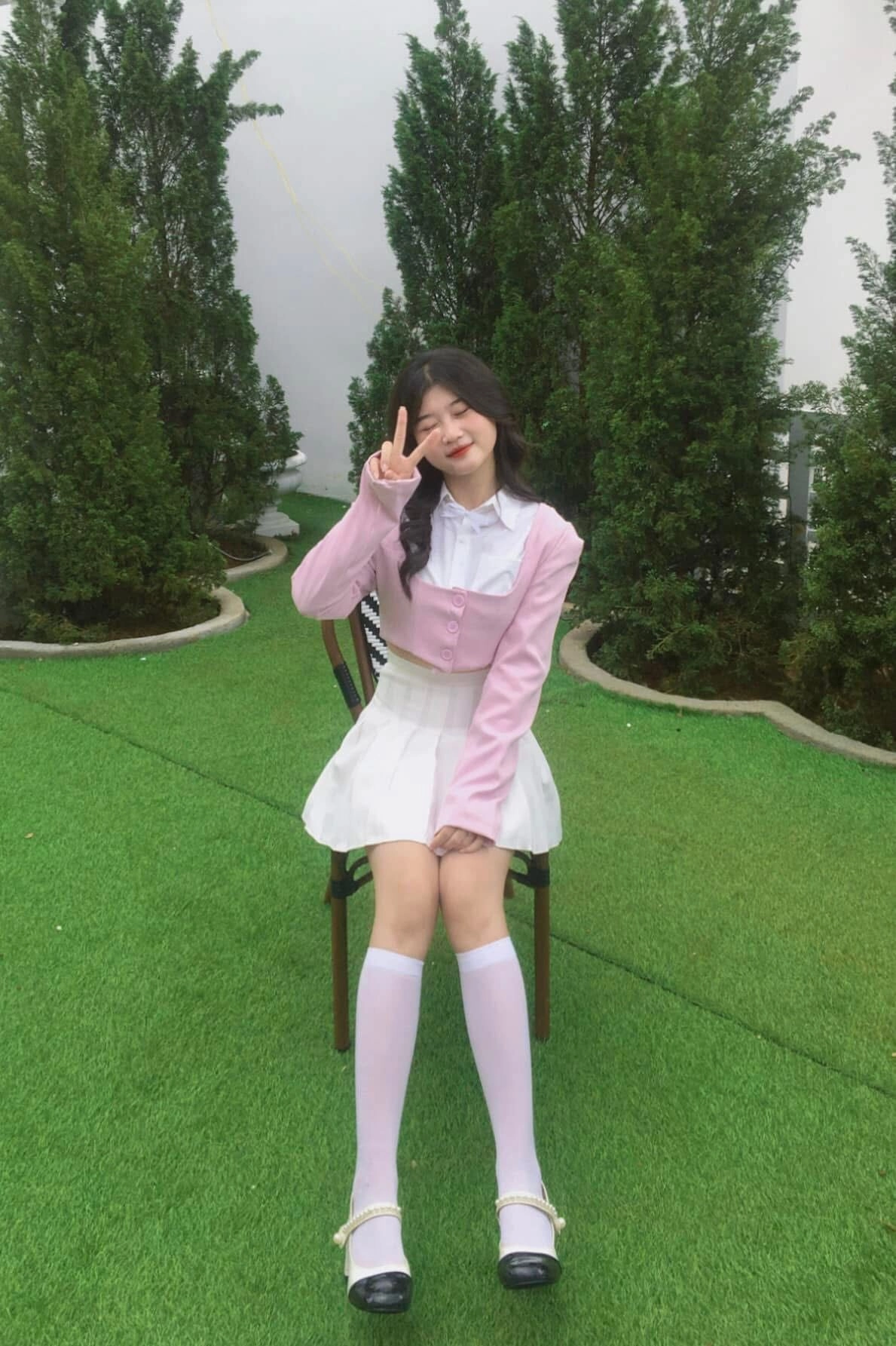 Phối đồ style học sinh với váy xếp ly, cardigan hồng và tất cao dễ thương.