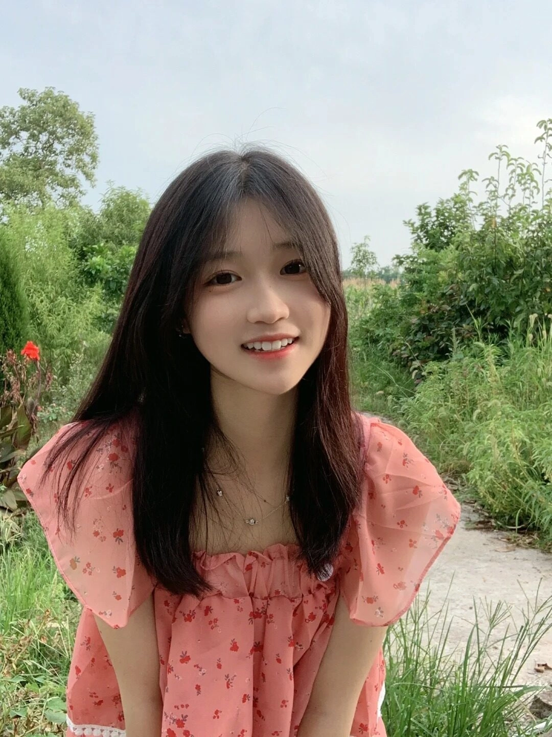Nữ sinh 2k9 khoe nụ cười rạng rỡ trong chiếc váy hoa hồng nhẹ nhàng, tỏa sáng giữa thiên nhiên. 
